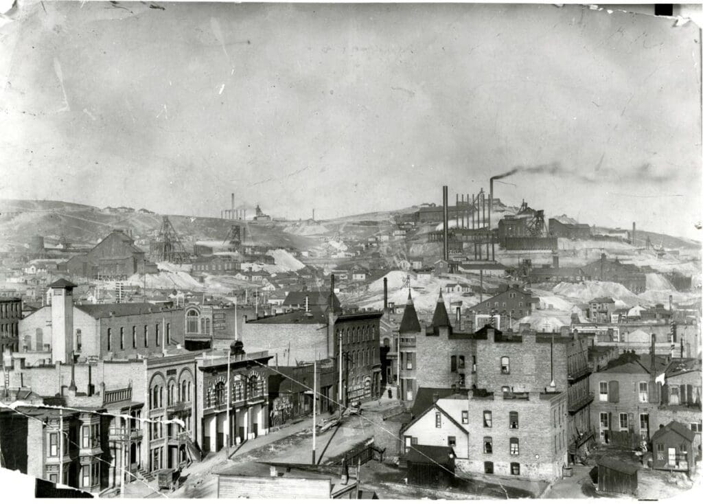Mines - Butte hill showing: Dublin Gulch area, East Steward Mine, two Nipper Mines, (L-R top row) High Ore, Parnell, L.E.R., Virginus, Mt. View, (down) Anaconda, Neversweat, Parrot, Washoe, Colusa Parrot, `St. Lawrence. Fire Hall on Quartz Street. Large building on left is the Miner's Union on North Main Street which was later blown up. Circa 1900